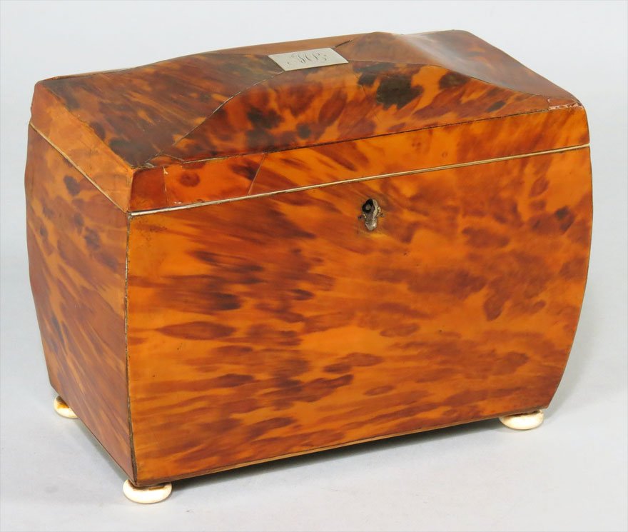 ENGLISH GEORGIAN TORTOISE SHELL TEA CADDY: coffin-form, the slightly domed top with silver monogram MB, double interior with tortoise lids, ivory bun feet, 6”h; 7.25”w; 4”d
