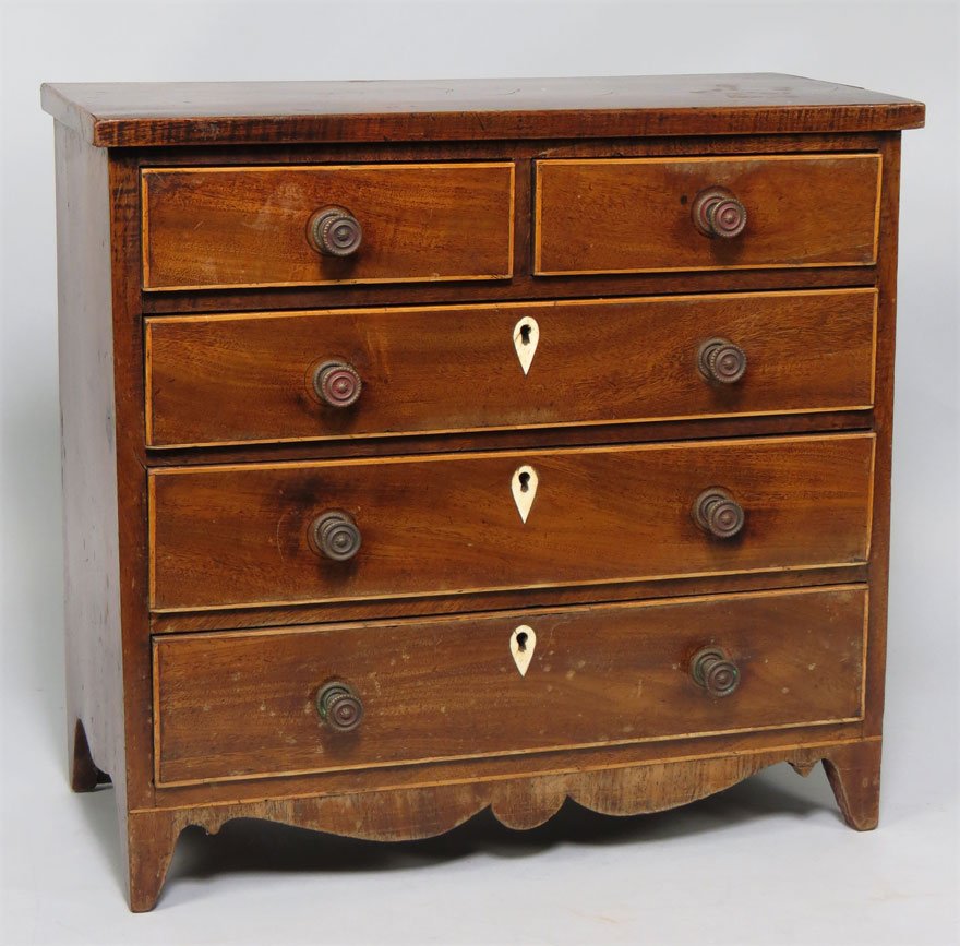HEPPLEWHITE MINIATURE MAHOGANY CHEST OF DRAWERS: two inlaid drawers over three, all with turned brass knobs, the long drawers with ivory escutcheons, shaped apron, flared feet, 14.5”h; 15”w; 7”d