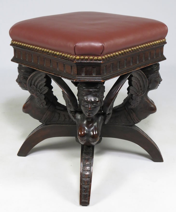 19TH C. CARVED WALNUT FIGURAL FOOTSTOOL: square faux leather seat supported by four carved mythological winged female figures, on carved sabre legs, 20”h; 17”square