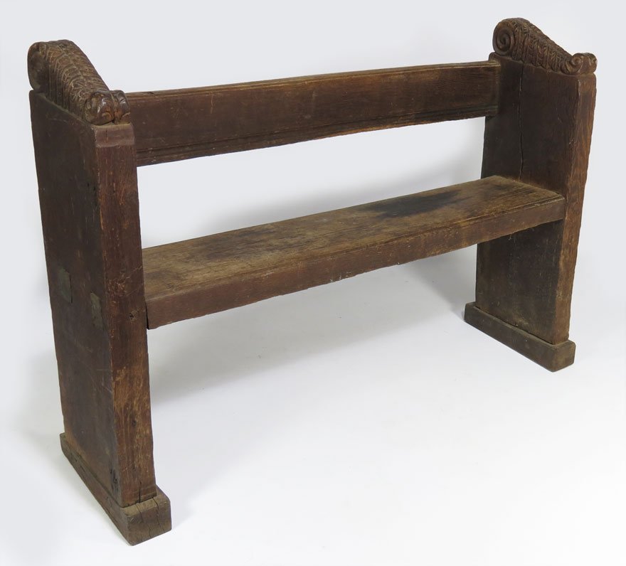 EARLY ITALIAN CARVED WALNUT BENCH: 18th c. or earlier, high thick plank sides with stylized feathered carving at top, mortised single plank seat, shoe foot, 35.5”h; 51.5”w; 12.5”d