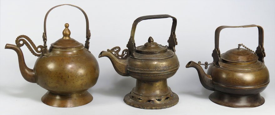 (3) RENAISSANCE BRONZE KETTLES: 17th c. or earlier, repousse design, lid attached with chain, 8" h to top of finial (small wear hold in foot, swing handle damaged); along with footed bulbous bronze with swing handle, 9" to top of fi