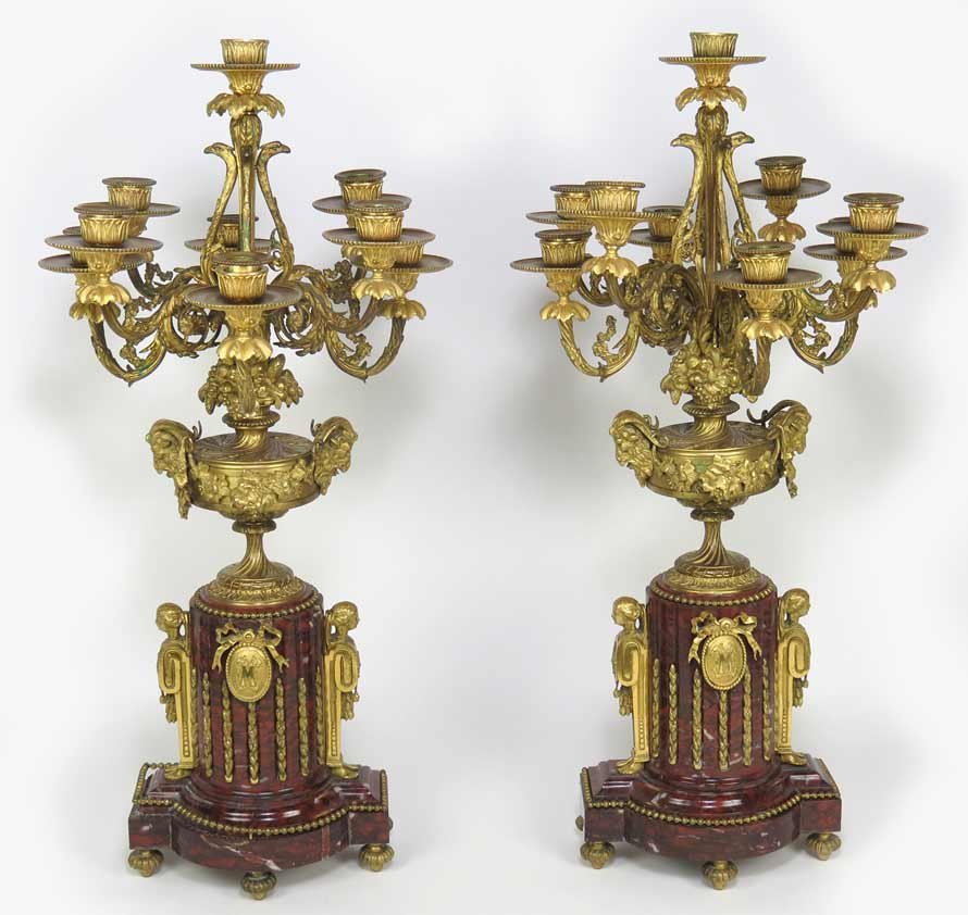 PAIR OF FRENCH MARBLE AND BRONZE 9-LIGHT CANDELABRA: 19th c., the firegilt bronze candlearms mounted on bronze urn with rams’ head handles, on fluted marble plinth with ormolu mounts, 25.5”h