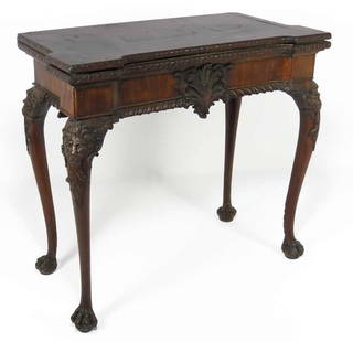 FINE IRISH GEORGE II CARVED MAHOGANY GAMING TABLE: 18th c., hinged lid with carved alternating flower and ribbon border, the apron with gadrooned edge and large carved acanthus leaf; the interior with counter wells, the playing surface with fanciful n