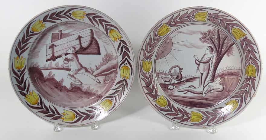 PAIR OF 18TH C. POLYCHROMED DELFT CHARGERS: yellow tulip border mulberry center, one Adam and Eve, the other, figure carrying doors up a hill, each with blue under glaze mark, 13.75”diam.