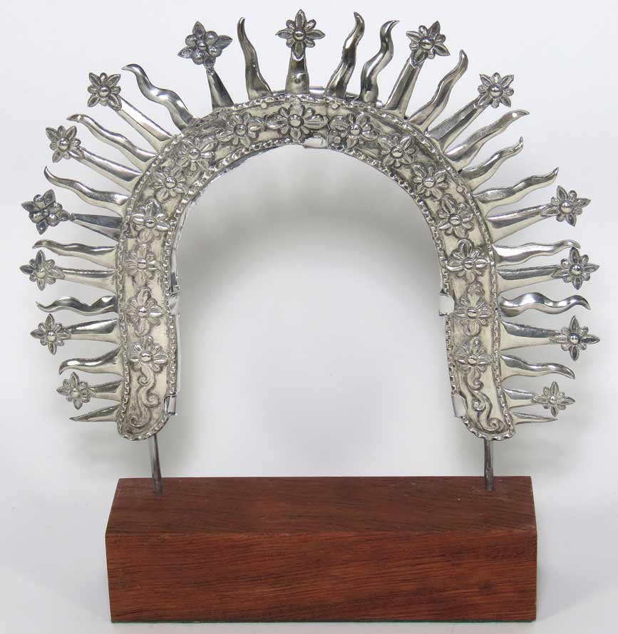 SPANISH COLONIAL SILVER RESPLENDOR: c. 1800, possibly Guatemala, unmarked floral frame with alternating rays and floral darts, originally crowned the head of a large santo, 8”h; 11”w; mounted on wire frame and wood baseFrom the coll