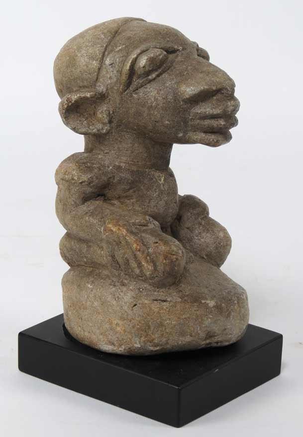 ARCHAIC STONE NOMOLI FIGURE: Sierra Leone, poss. Mende, carved light-brown stone, male figure seated on a stool, 6”, wood base Prov.: Sotheby’s, New York, sale 7930, lot 47 The David Abbate (1949-2013) Collection Nomoli figur