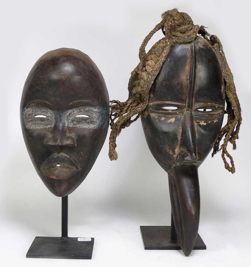 (2) DAN MASKS: Ivory Coast, with hornbill-beak mouth, wood and braided twine, 15.5”; 6”w (minor traces of white, particularly under eyes; braided old twine hair detached at crown); along with another mask (trace