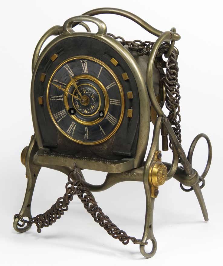 UNUSUAL BRASS HORSE-BIT MANTEL CLOCK: c. 1900, constructed of horse bridle bits and chains, metal face with Roman numerals set in horseshoe, strikes on hour and half hour, original key on bridle lead hook, 10.5”h; 7”w Ex. Kurt Reynold