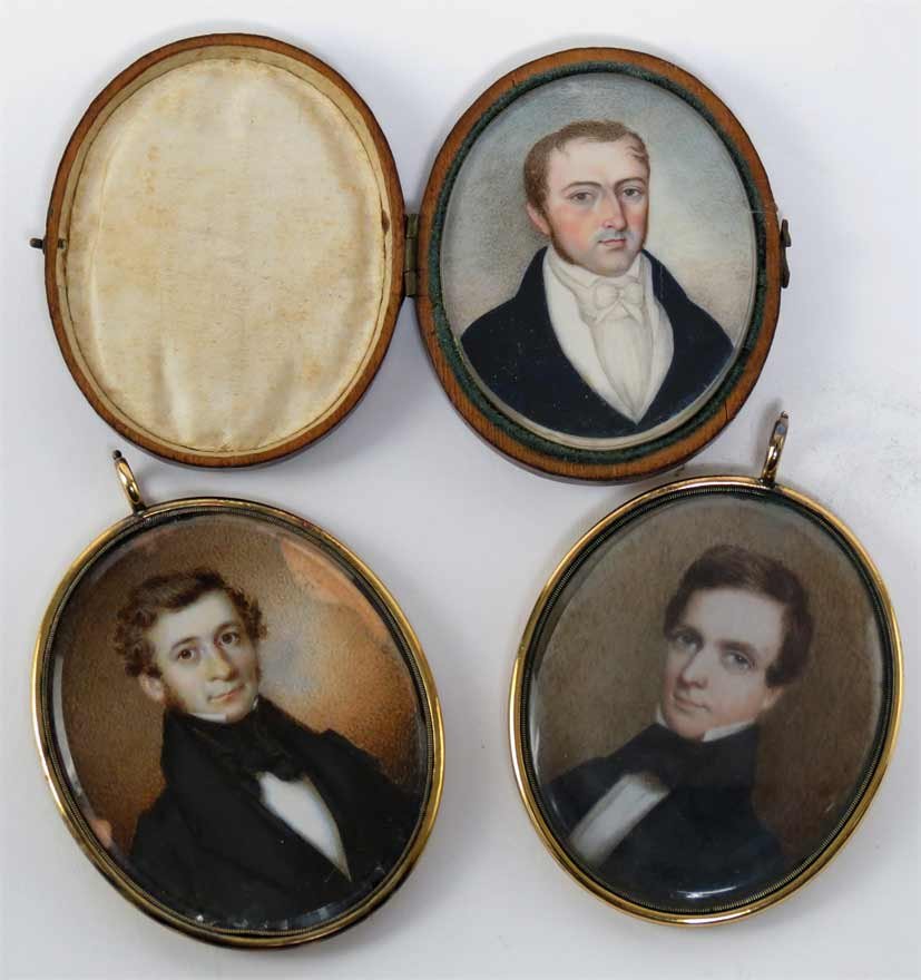 (3) MINIATURE PORTRAITS OF GENTLEMEN: early 19th c., oval, oil on ivory, one in original hinged leather case; two encased in brass frames with window on reverse, one with locket of hair (paint loss to edges); the other contains old fabric