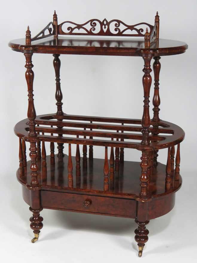 EDWARDIAN BURL WALNUT CANTERBURY/STAND: oval-form, with pierced gallery, divided section with turned supports below, with drawer, turned legs on brass casters, 41”h; 31”w; 18”d