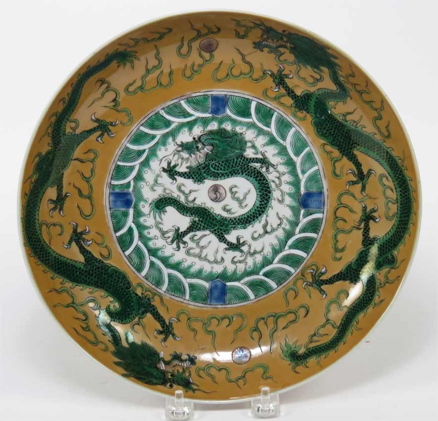 CHINESE DRAGON DEEP DISH: 19th c. or earlier, green dragon in center with pair of dragons to border and repeated on underside on pale brown ground, six blue marks on bottom, 10.25”diam.