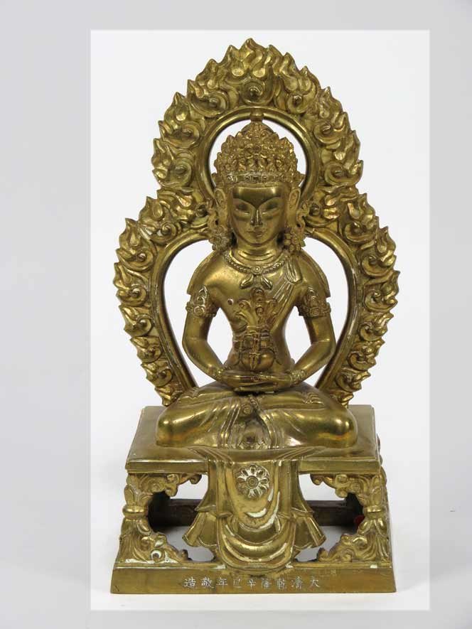 SINO/TIBETAN GILT BRONZE BUDDHA: 19th c., Amitayus, seated on platform throne in dhyanasana, holding a vase, detachable flaming mandorla, incised calligraphy on front base of throne, copper seal on bottom intact, 9” Ex. Kurt Reynol