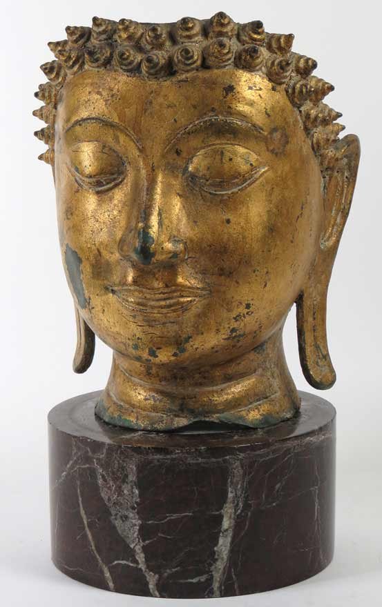 EARLY CHINESE GILT COPPER BUDDHA HEAD: Thailand, 11”h; 8”w; 7”d; on an assembled round red marble base, 4”h; 7.5”diam. Ex. Kurt Reynolds collection, Boston