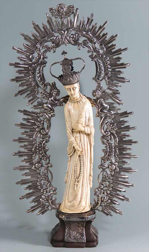SPANISH COLONIAL FIGURE, MARY MAGDALENE: Hispano-Filipino, 1750-1815 carved ivory full-figure of Magdeline holding a rosary in one hand, the Holy Grail in the other, wearing a silver crown and surrounded by a chased silver radiance; mounted