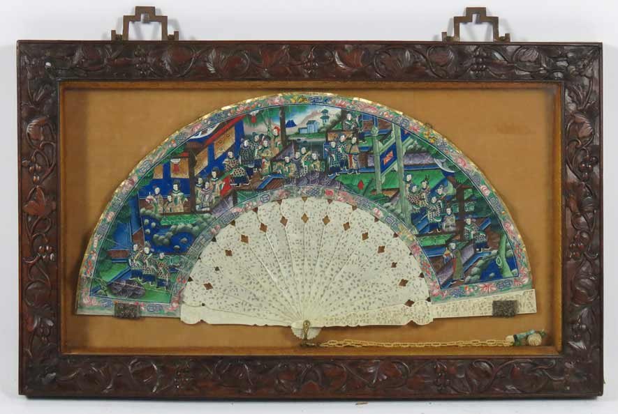 19TH C. CHINESE FAN: colorful gouache on paper depicting people, with ivory faces, in a pavilion landscape; the ribs of finely carved ivory, mounted in Chinese shadow box carved with vines, berries and flowers, under glas