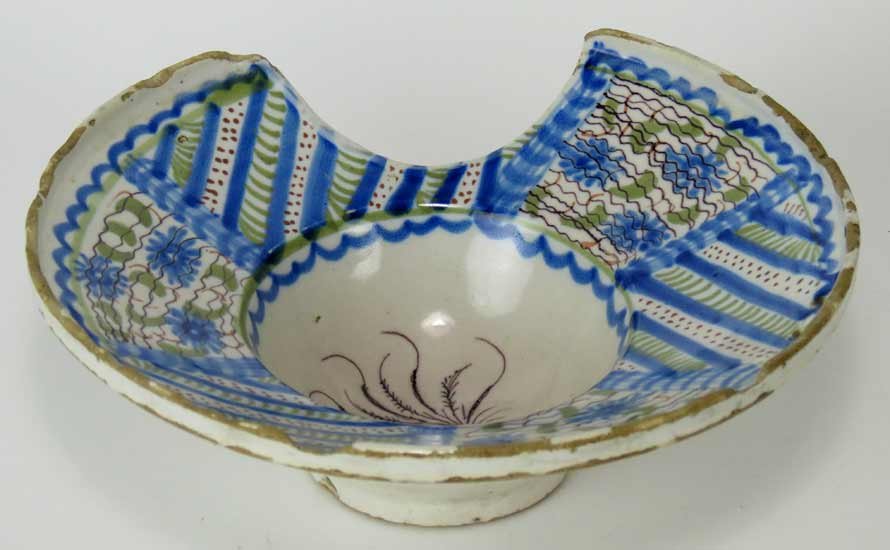 18TH C. CONTINENTAL FAIENCE BARBERS BOWL: poss. French, wide rim with blue line and floral decoration with two holes for hanging, 3.5”h; 9.5”diam.