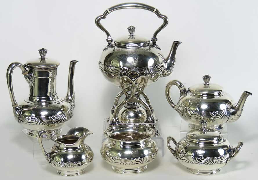 TIFFANY STERLING SILVER TEA AND COFFEE SERVICE: Wave Edge pattern, TIFFANY & CO./#1982M5947/STERLING SILVER six pieces consisting of tipping kettle on stand, coffee pot, a teapot, a covered sugar, a creamer and a waste bowl, 122 troy oz.