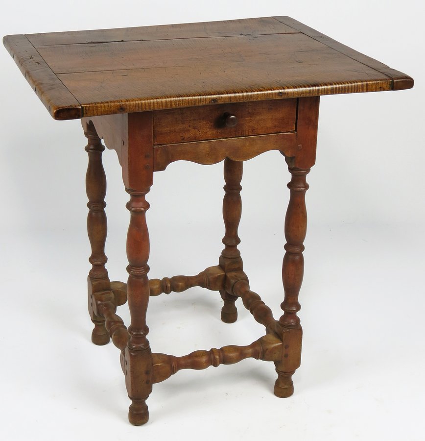 NEW ENGLAND WILLIAM AND MARY TIGER MAPLE TEA TABLE: early 18th c., rare diminutive size, traces of old red and green underneath, bread board top, one drawer, shaped apron all around, vase and ring turned legs with conforming turned stretchers, 26”h;
