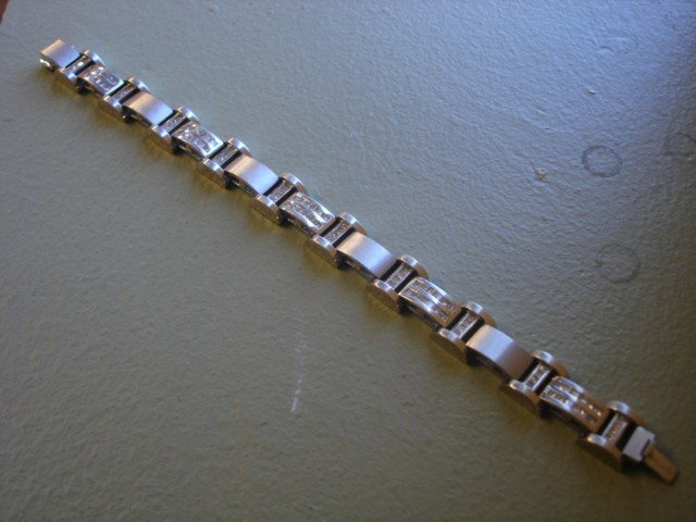 4.08 CT TW Diamond Bracelet with AIG Certificate: One tested 14k white gold gents cast & assembled diamond bracelet. Condition is new, good workmanship. Eight and one half inch terminating in a box clasp with safety bar. Bright and brushed finish, Id
