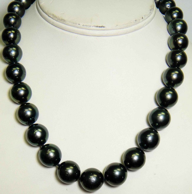 15.55mm - 12mm Tahitian Cultured Black Pearl Necklace: One graduated single strand pearl necklace eighteen and one half inch princess length, knotted with an 14KT white gold twelve and one-half millimeter scalloped plunger style clasp containing thirty th