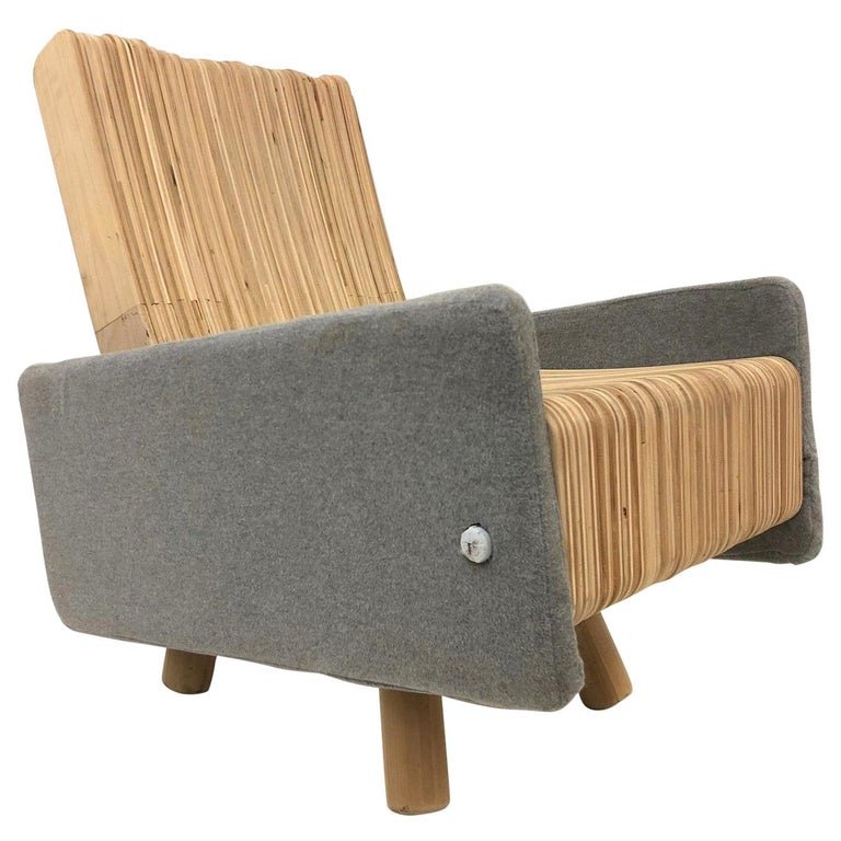 Custom Plywood Lounge Chair: The chair is made up of individual plywood slats that move outward. The legs are wood with felt fabric to the sides and back. Measures: 33.5H x 22W x 34.5D. SH: 18