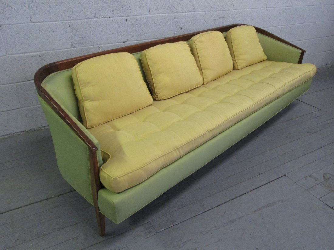 Paul McCobb Style Upholstered Sofa: Curved walnut framed sofa with loose back and seat cushions. Will need to be redone over. Measures: 90"W x 32"D x 28"H.