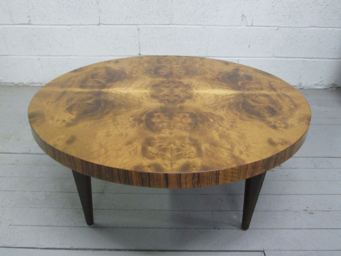 Gilbert Rohde Paldao Coffee Table: Has leatherette tapered and brass studded legs. Top is burl. Measures: 36" in diameter x 15.25"H.