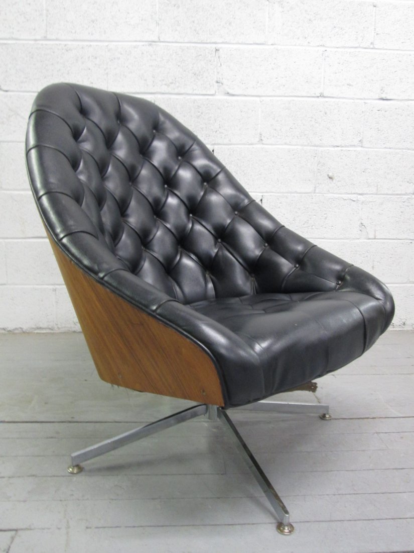 Milo Baughman Swivel Chair Labeled: Tufted black vinyl chair with walnut back and chrome legs. Has label. Measures: 36.5"H x 27.5"W x 34"D.