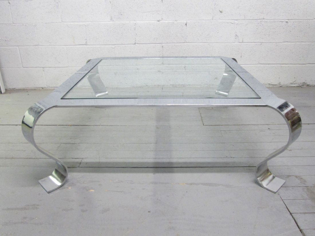 Polished Chrome Coffee Table by Brueton: Polished chrome frame and glass top with curved legs. Measures: 46.25"W x 46.25"D x 16.5"H