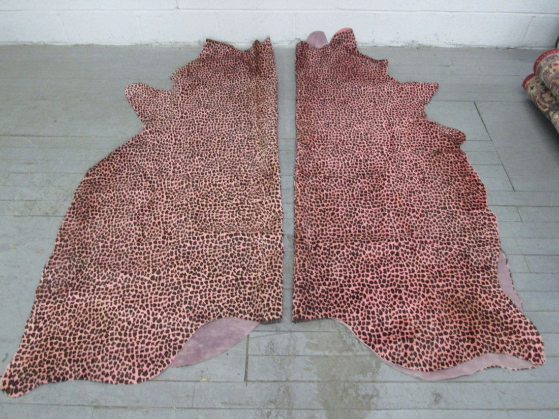 Pair Brazilian Stenciled Cowhide Rugs: Jaguar Stenciled print on pink background. Each measures approx 5x7. First picture shows both folded lengthwise.