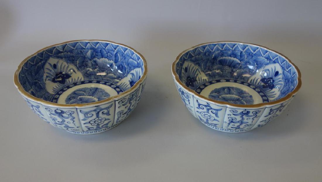 Japanese Blue & White Imari Porcelain Bowls, Pair: A pair of Japanese Imari porcelain serving bowls. Early to mid 20th century. Lobed form having scalloped edges, underglaze blue and white decoration depicting abundant flowers and foliage. Each measur