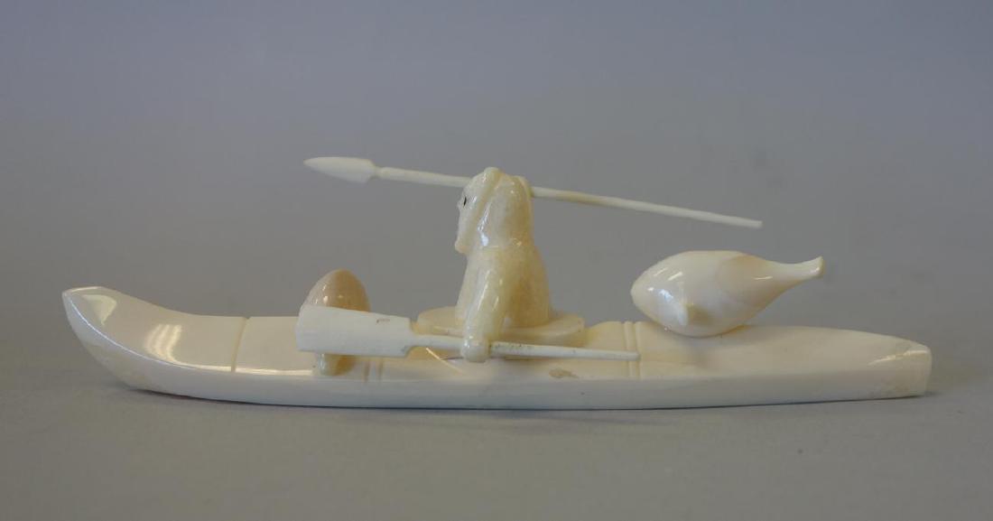 Alaskan Inuit Carving, Seal Hunter in Kayak, Signd: An Alaskan Inuit carving. Signed on the underside, Koyuk. Carved from walrus tusk to depict a male Inuit figure hunting in a kayak with spear and paddle. Measures 5.25" long, 1-3/8" high, 1.75" wide.