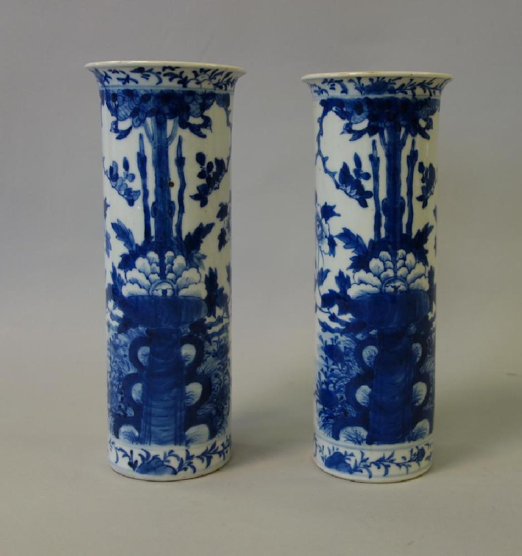 Chinese Blue & White Porcelain Cylinder Vases: A pair of Chinese blue and white porcelain cylinder vases, 19th century Qing Dynasty. Each decorated in underglaze blue enamels, depicting abundant florals, leaves and vines and butterflies. Measuring