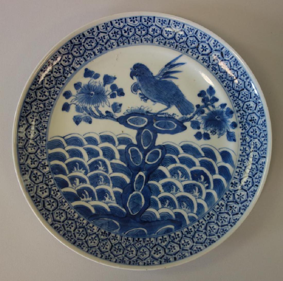 Chinese Blue & White Porcelain Plate, Parrot Ptn: A Chinese porcelain plate, 19th century. Unique motif of blue and white underglaze enamels depicting a parrot among florals over a wavy sea. Geometric "tortoise" motif surrounding the border. Measures