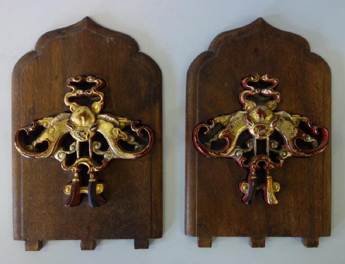 Chinese Carved & Gilded Bat Book Rack Ends: Two Chinese carved wood book rack ends / bookends. Each inset with a well carved wood red painted and gilded bat. Dovetail ends. Measuring 7-5/8" high, 5" wide. NOTE: Missing flat connecting surface.