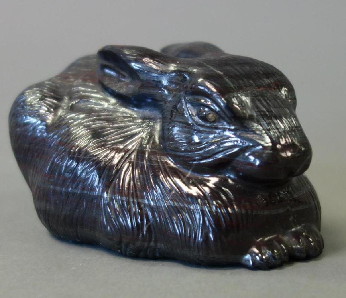 Russian Carved Stone Rabbit With Diamond Eyes: A Russian hand carved stone rabbit with mine cut diamond eyes. Black / deep purple stone with white / silver and red striations. Measures 4" long, 2.75" wide, 2" high. Unsigned.