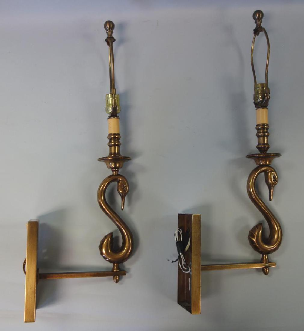 Frederick Cooper Brass Sconces, Swan Form: A pair of brass wall sconces by Frederick Cooper, Chicago. Swan formed lamps surmounted by one candle formed socket. Measures 25.5" high to top of finial, 20" high to top of socket, 9" deep, 3.75" wid