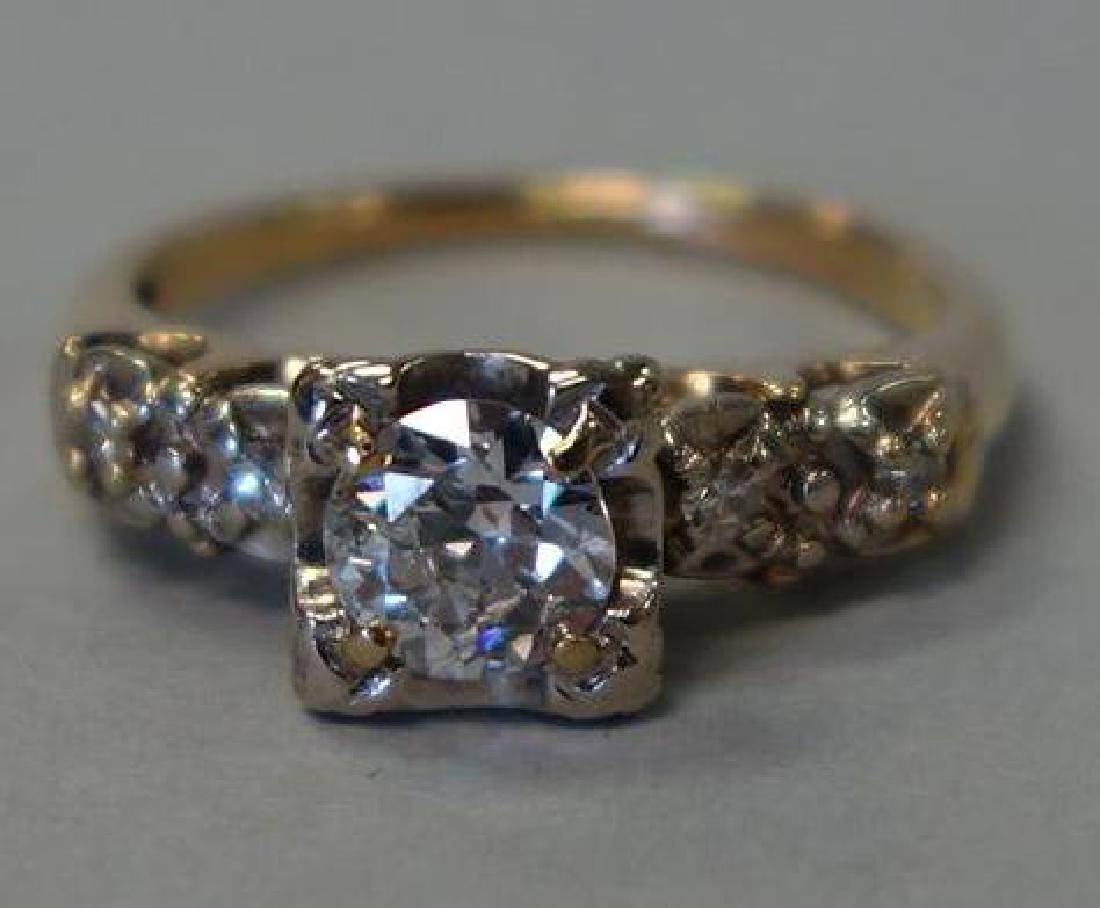 Diamond & 14K White & Yellow Gold Ring: A ladies diamond and 14K gold ring. The ring is centered with a brilliant cut diamond of approximately .50 carats, Clarity SI-2, Color I-J and flanked on each side with two single cut diamonds. These 