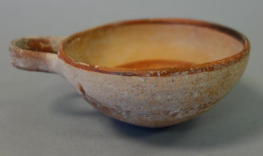 Ancient Greek / Etruscan Pottery Wine Cup: An ancient Greek / Etruscan pottery one handled wine cup, 5" wide to end of handle, 1.75" high, 3.75" diameter. CONDITION NOTE: crack to interior. See photos.