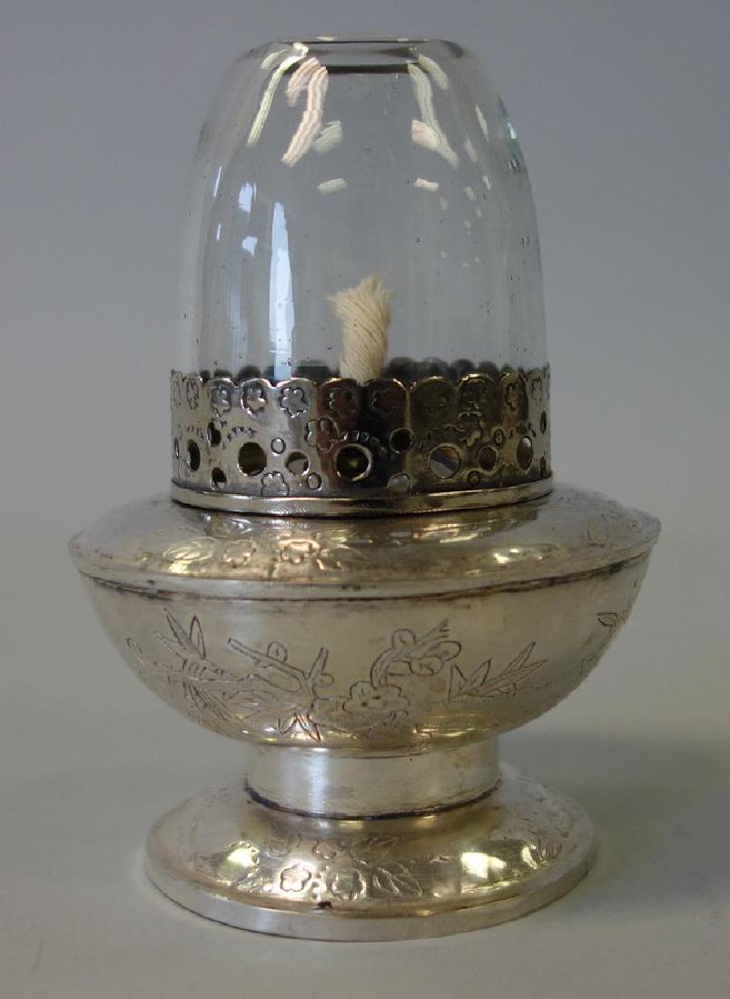 Chinese Silver & Glass Opium Lamp: A Chinese silver and glass opium lamp. Characteristic glass funnel shade with silver band, resting on a silver base decorated with flowers, leaves and foliage and Chinese calligraphy characters. Measu