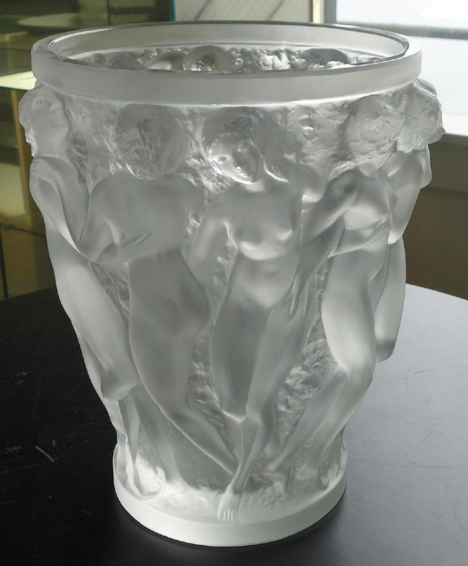Lalique Bacchantes Vase, Nude Dancing Females: A French art glass vase by Lalique, France. Titled Bacchantes. The tapering vase depicts the young priestesses of Bacchas, naked in a bas-relief, performing a round dance to celebrate the god of wine.