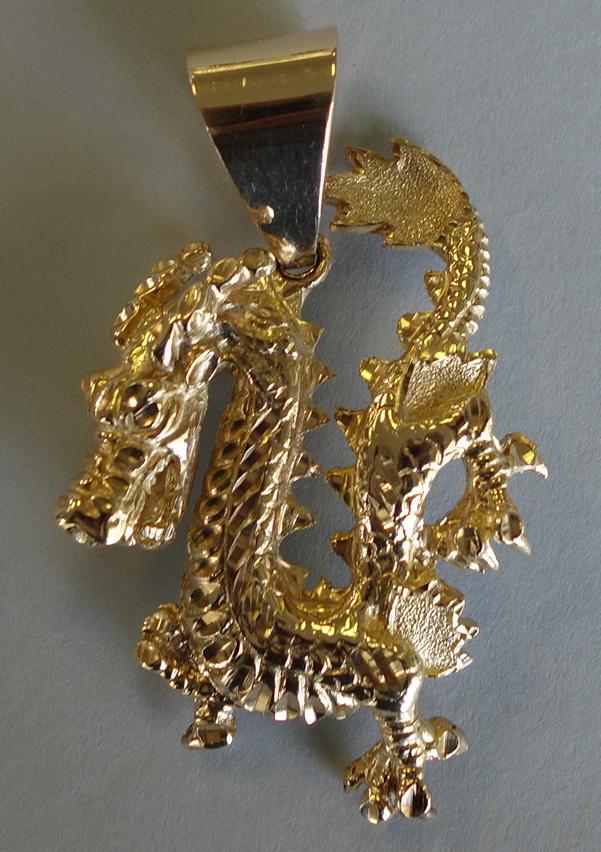 Fine & Large 10K Gold Dragon Pendant, 85 grams: A fine and large 10K yellow gold pendant. Formed as a dragon. Well detailed measuring 3" high to top of bail, 1-7/8" wide, 3/8" to .5" thick. The bail stamped 10K. Weighs 85 grams.