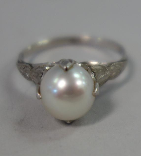 Vintage 18K White Gold & Pearl Ring: A vintage 18K white gold ring centered with a cultured pearl measuring approximately 9mm. Ring size 6. Acid tested as 18K gold. Indistinct stamp on interior of band...appears to be PM1. Weighs 3 grams