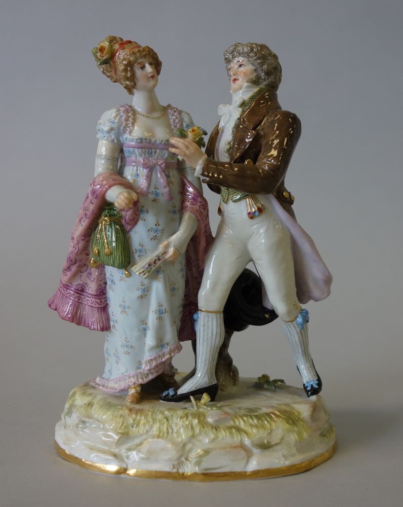 Meissen Porcelain Figurine Courting Couple K 163: A fine Meissen porcelain figurine / figural group depicting a young man and woman in period 19th century costume. The man courts the young woman with the offering of a flower. The couple stand on a re