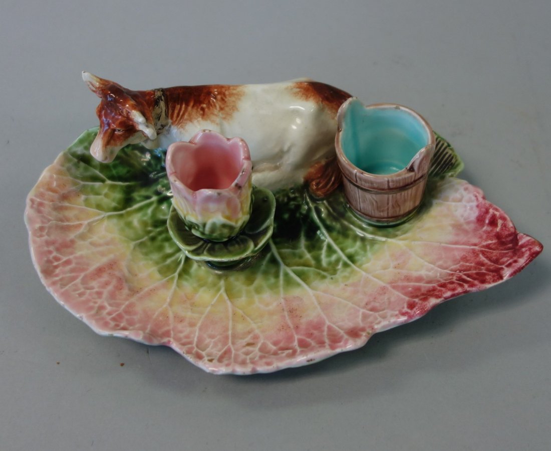 19thc Majolica Figural Cow Candleholder / Toothpick Hld: A majolica figural candle holder / toothpick holder, 19th century. Leaf formed tray featuring a cow resting beside a milking pail and a tulip formed candleholder. The underside impressed with the numb