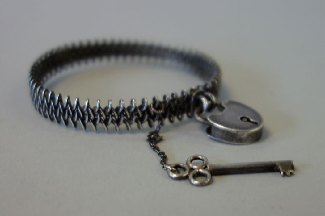 Victorian Silver Entwined Bracelet With Lock & Key: A Victorian silver entwined bracelet with shaped lock clasp and key. Interior circumference 6" x 3/8" wide.