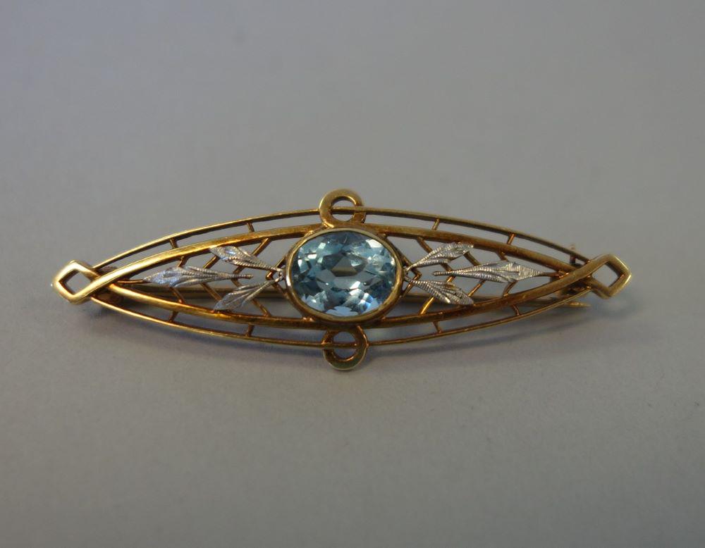 Vintage 14K Gold Aquamarine Brooch Pin: A vintage 14K gold and aquamarine brooch pin. Fine openwork brooch of 14K yellow and white gold. The brooch is centered by an oval faceted aquamarine of approximately 1.30 carats and flanked by a leaf