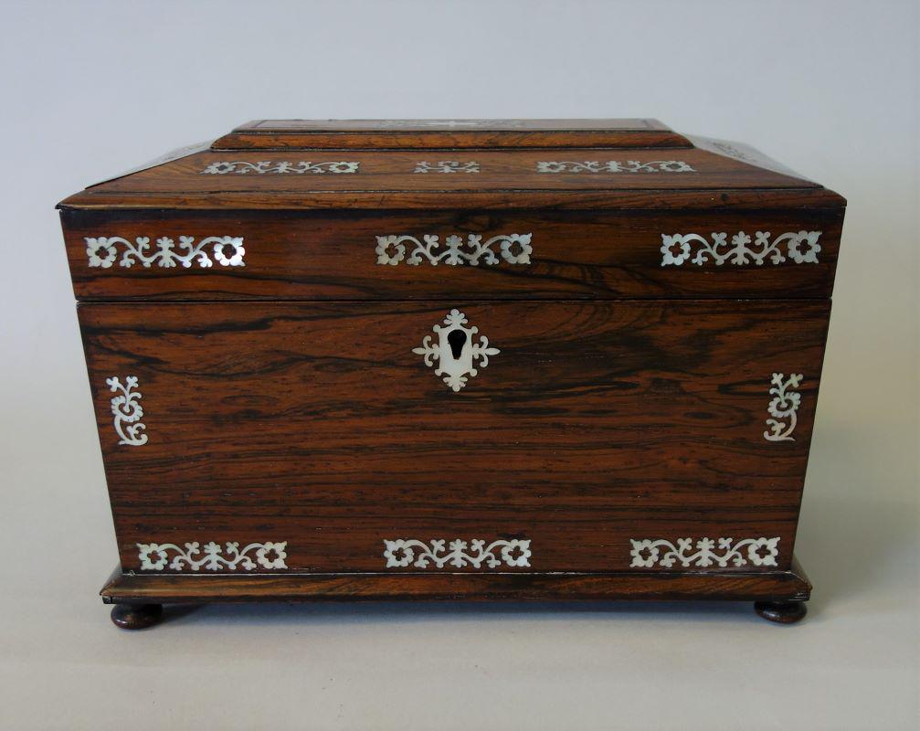 19thc Rosewood & Mother of Pearl Tea Caddy: A fine English rosewood and mother of pearl tea caddy, c.1870s. Sarcophagus form supported on four bun feet. Intricate mother of pearl inlay on the hinged lid, front face and escutcheon. Lion face and