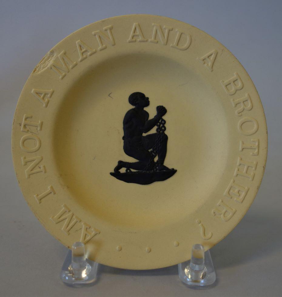 Wedgwood Dish, Am I Not a Man and a Brother?: A Wedgwood commemorative yellow jasperware dish. The dish is centered with the image of a black man in chains depicted as a slave. Words surrounding the image on the border read "Am I Not A Man And A