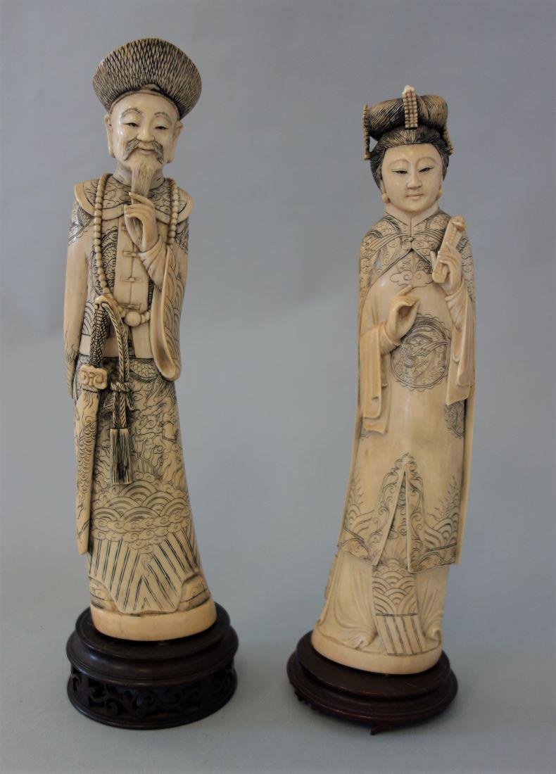 Chinese Ox Bone Carvings of Emperor & Empress: A vintage Chinese pair of ox bone carvings. Finely carved to depict the Emperor and Empress. The emperor holds a ceremonial sword and the empress is depicted holding a ruyi scepter and wearing a headd